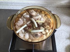 烧一锅热水，把煮猪蹄的水换掉，加入大葱段、八角、1小勺黄酒、姜片、泡发好的白芸豆，先大火煮开