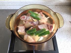 猪蹄烧一下，去掉毛，清洗干净，砍成小块（当然这些过程菜市场卖主题的阿姨会免费帮你完成），锅里加水，倒入适量料酒，加入大葱叶子、生姜片1片，冷水下锅猪蹄，大火