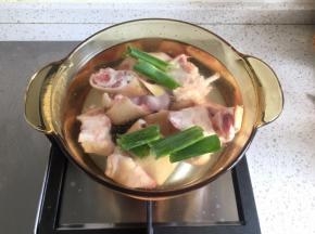 猪蹄烧一下，去掉毛，清洗干净，砍成小块（当然这些过程菜市场卖主题的阿姨会免费帮你完成），锅里加水，倒入适量料酒，加入大葱叶子、生姜片1片，冷水下锅猪蹄，大火