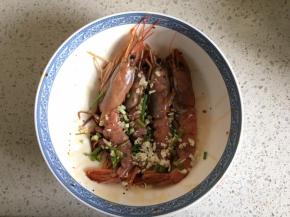 香葱切段、大蒜切末，倒入碗中，加入生抽、老抽、料酒、白胡椒粉，把虾放进去，均匀涂抹上料汁，腌制20分钟