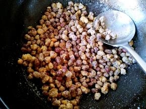 把前面炸好的花生倒入锅中，快速翻炒均匀关火。