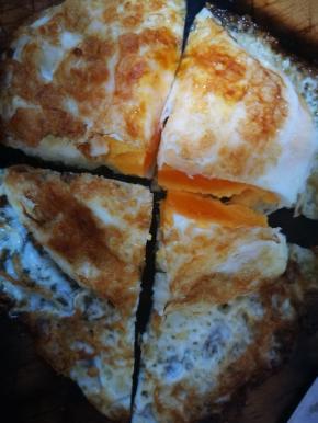 两面煎熟，蛋黄要煎凝固，不然切开的时候会流黄，不要煎糊了。煎好后，取出切十字刀，4块