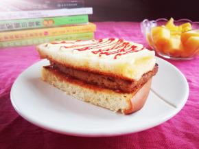 将煎好的肉放在面包片上。最上面再挤点沙拉酱和番茄酱，好滋味哦！赶紧趁热吃吧！