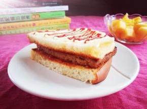 将煎好的肉放在面包片上。最上面再挤点沙拉酱和番茄酱，好滋味哦！赶紧趁热吃吧！