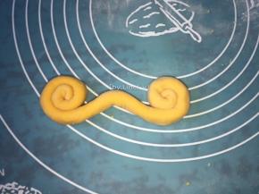 将条状的面两端同时向中间卷起
