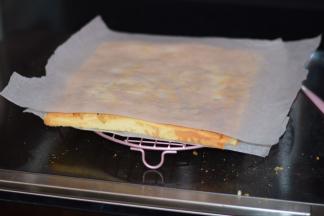 10，烤好的蛋糕要立即取出，震出热气后，在表面垫上一张烘焙纸，然后倒转过来。