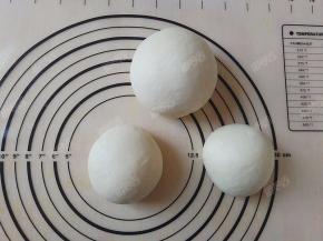 将面团平均分割成两份，然后将其中一份再一分为二，滚圆盖保鲜膜松弛大约20分钟