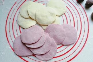 然后将双色小面团分别擀成中间厚四周薄的圆面片；