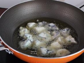 锅中倒入适量的花生油，油温160度左右，放入裹好浆的茄块；