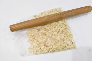 取100克花生仁放入保鲜袋用擀面杖稍微压碎一点；（也可以放整颗的，依个人喜好吧）