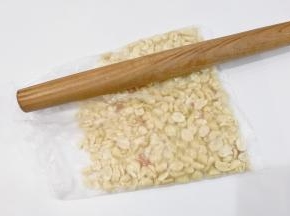 取100克花生仁放入保鲜袋用擀面杖稍微压碎一点；（也可以放整颗的，依个人喜好吧）