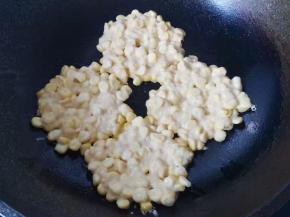 锅中倒入少许油，把玉米糊均匀的摊成玉米饼；