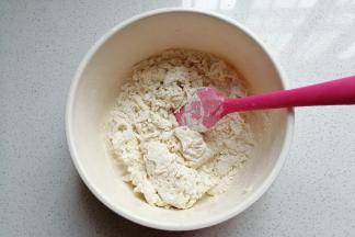 先做白面团：称好面粉，加入白糖。然后用温水溶化酵母，再把酵母水倒入面粉中拌成棉絮状；