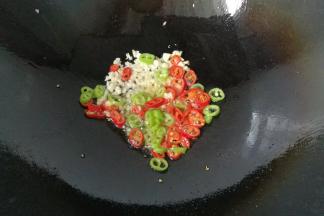 锅中留少许底油，先下蒜末和青红椒煸出香味；
