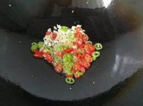 锅中留少许底油，先下蒜末和青红椒煸出香味；