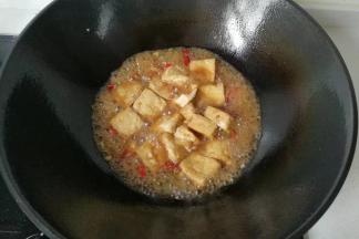 下入炸好的臭干子，烧煮至浓稠收汁；