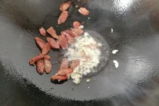 锅中入适量油，先下蒜煸香，再下腊肠煸香；