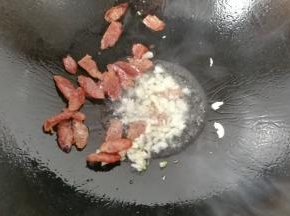 锅中入适量油，先下蒜煸香，再下腊肠煸香；