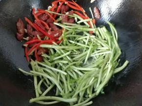 接着下入泥蒿，翻炒均匀；