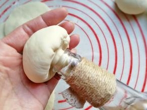 包好后，把小揪揪插入碑酒瓶中向上顶压一下，一样会更像小蘑菇啦；