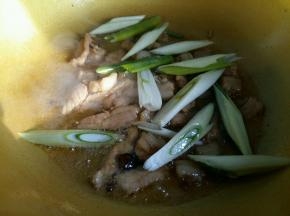 猪肉翻炒完全变色后放入葱段。
