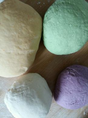 在紫薯和南瓜中分别加入面粉揉成面团。再揉一个不带颜色的面团。做出白色，紫色，绿色，黄色四种面团。