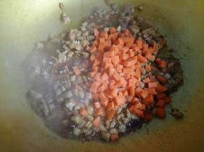 鸡肉翻炒变色后倒入胡萝卜丁翻炒1分钟。