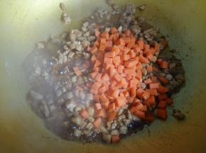 鸡肉翻炒变色后倒入胡萝卜丁翻炒1分钟。