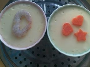 蒸好的蛋羹揭开，放入虾仁和胡萝卜，盖上盘子继续蒸3分钟。