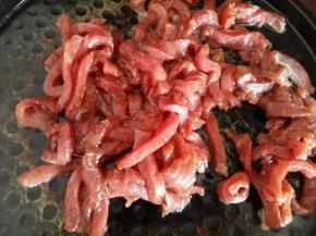 热锅凉油，倒入腌制好的牛肉翻炒。