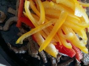 牛肉变色后倒入彩椒。
