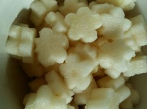 雪梨切成片，用模具压成花朵形状。