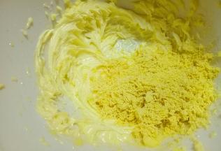 打至黄油体积膨大，蓬松状态了加入过细筛的蛋黄，用硅胶铲搅拌均匀。