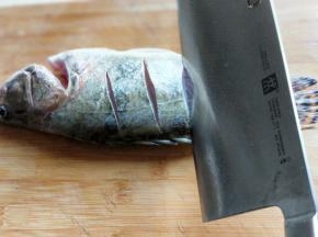 洗干净的鱼，鱼身体两面用刀划几道，不要太深，