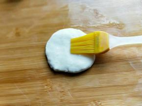 取一块面团，用掌心压扁，刷上一层玉米油。