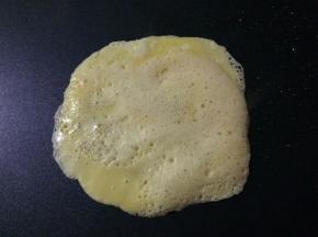 在煎饼神器上少上适量的食用油，倒入一大勺蛋液