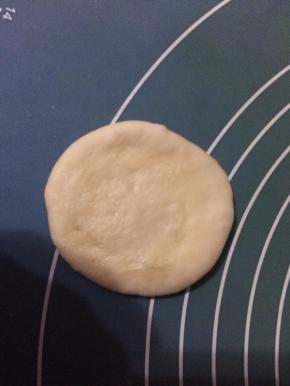 然后取一个面团，擀成小圆饼状