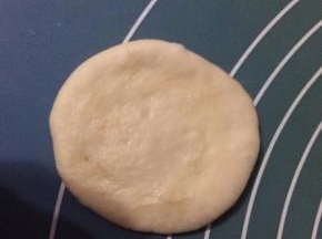 然后取一个面团，擀成小圆饼状