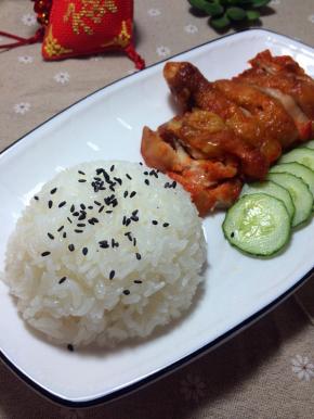鸡腿切块摆进盘子里，米饭也摆进盘子里，上面撒一点黑芝麻，码上黄瓜片，就可以开动啦