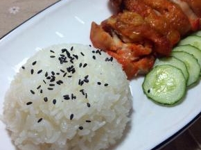 鸡腿切块摆进盘子里，米饭也摆进盘子里，上面撒一点黑芝麻，码上黄瓜片，就可以开动啦