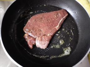 黄油化了以后，将牛排放入锅里，