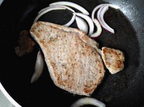 等一会儿牛排底部变色了，就翻面，再放入洋葱丝，