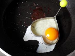 把剩下的黄油放入锅中，化开后，放入煎蛋模具，鸡蛋打入其中，