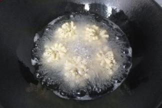 锅中入适量油，烧至五六成热时，放入菊花酥小火慢炸；