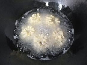 锅中入适量油，烧至五六成热时，放入菊花酥小火慢炸；