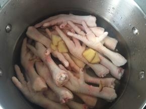 将鸡爪，姜，料酒倒入锅中，加没过鸡爪的水烧开后煮熟