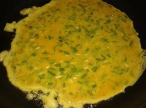 然后起油锅，倒入鸡蛋煎成饼子