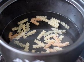砂锅里加入适量清水、把螺旋意面放入锅中煮沸后、小火继续煮8分钟左右即可捞出用清水冲洗干净、沥干备用