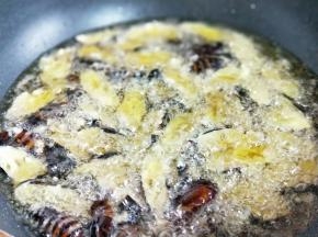 起油锅，油温7成时加入挂满面粉的蚕蛹，中火炸。