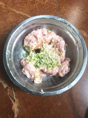 在搅打起劲的肉里加入胡椒粉，生抽，白糖，姜末，葱花，鸡精，蚝油。